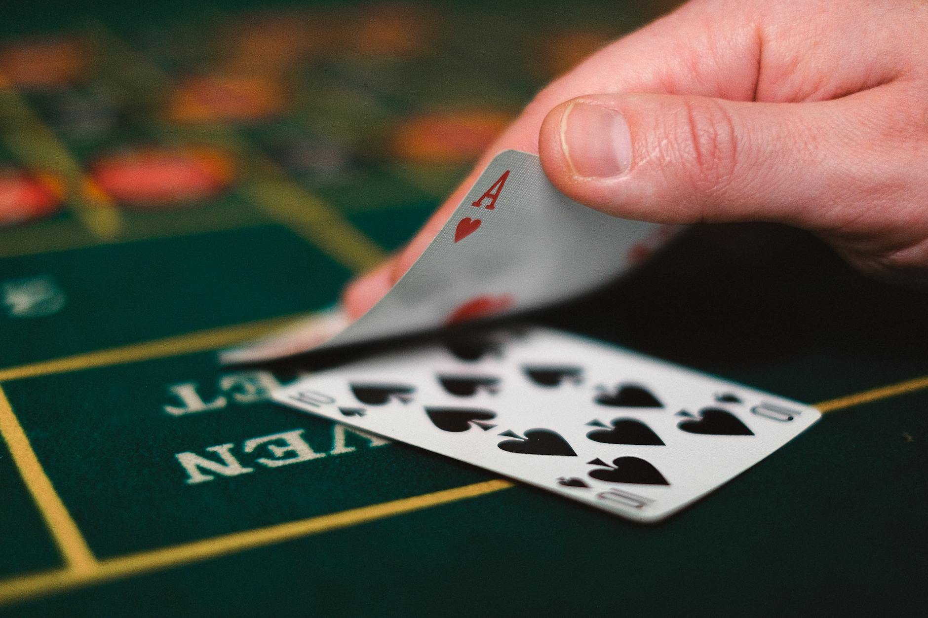 Một ván blackjack trên bàn xanh với lá bài và chip cược